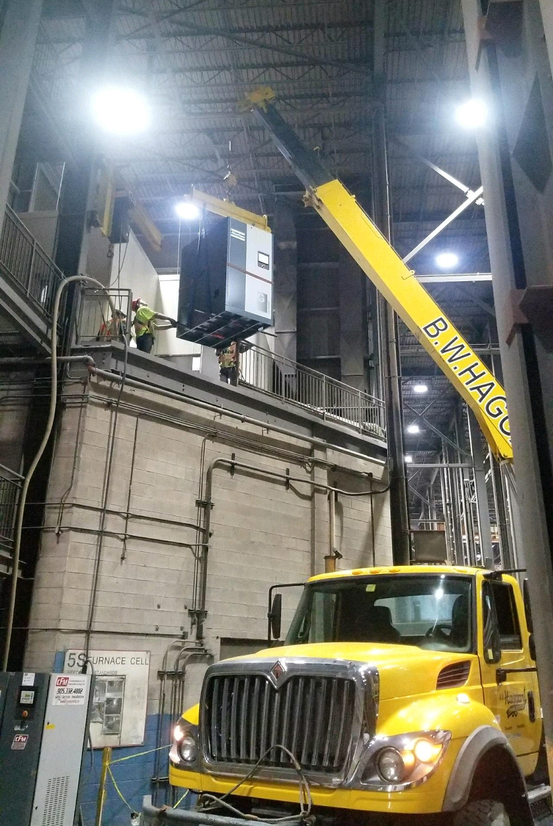 Rigging, hoisting  Atlas Copco air compressor onto customers mezzanine